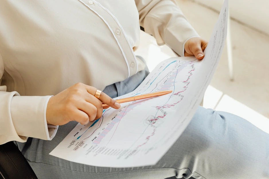 Professionisti in riunione analizzano grafici finanziari in un ufficio moderno.